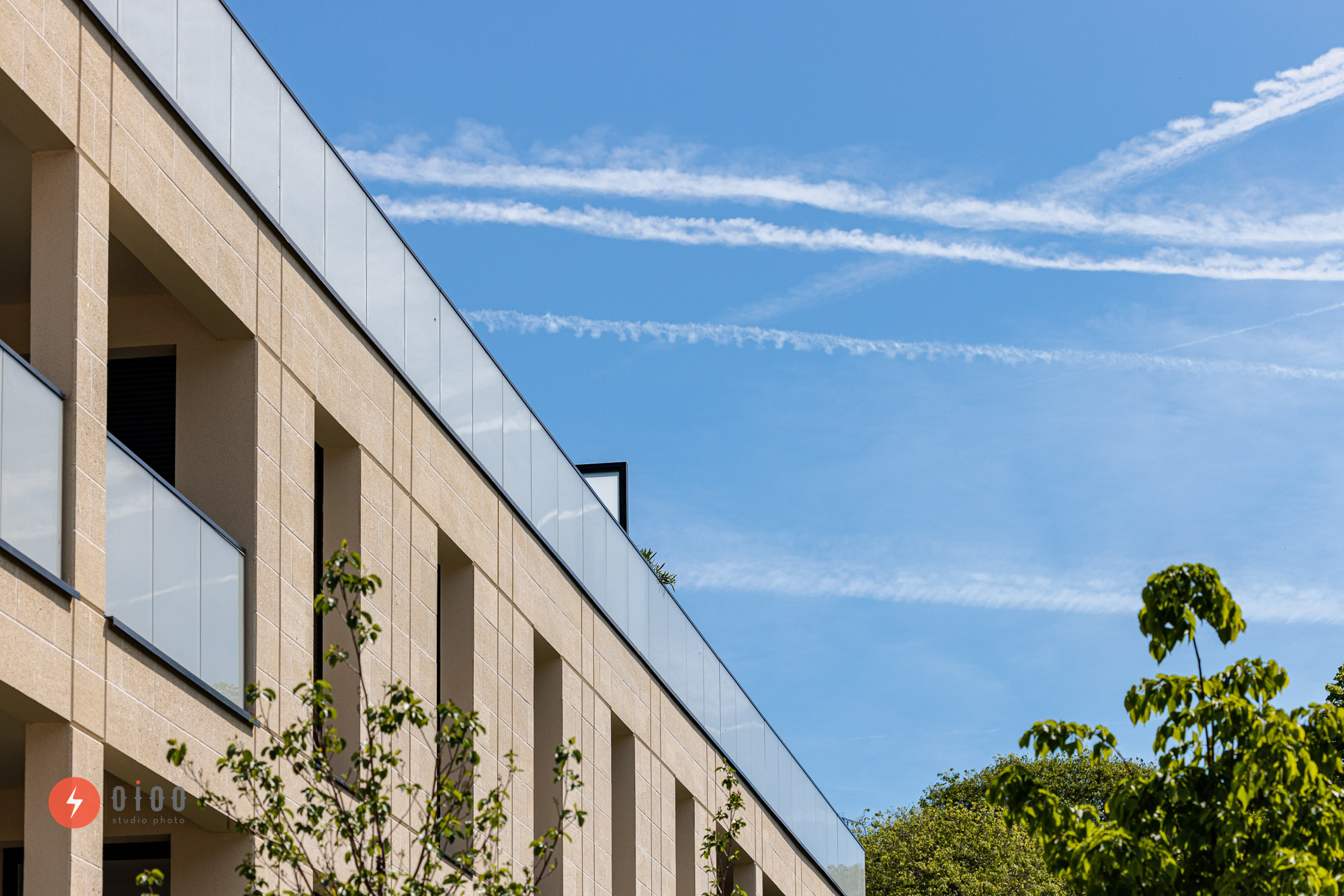 Photographie immobilière pour le groupe Lamotte à bordeaux par Oioo studio : vue d'un rooftop depuis le sol, en contre plongée, avec un ciel bleu