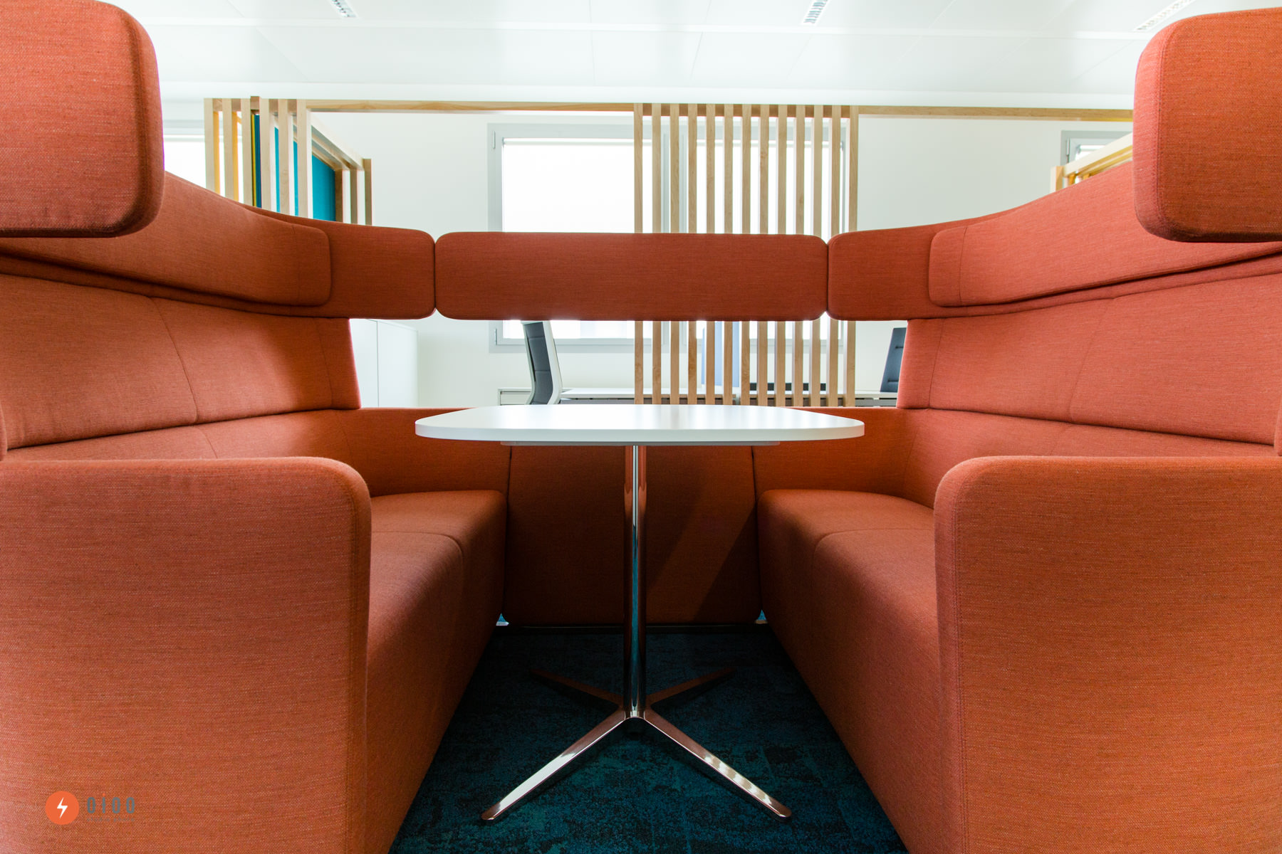 photographe design d'espace à Nantes : une petite table avec deux banquettes rouges