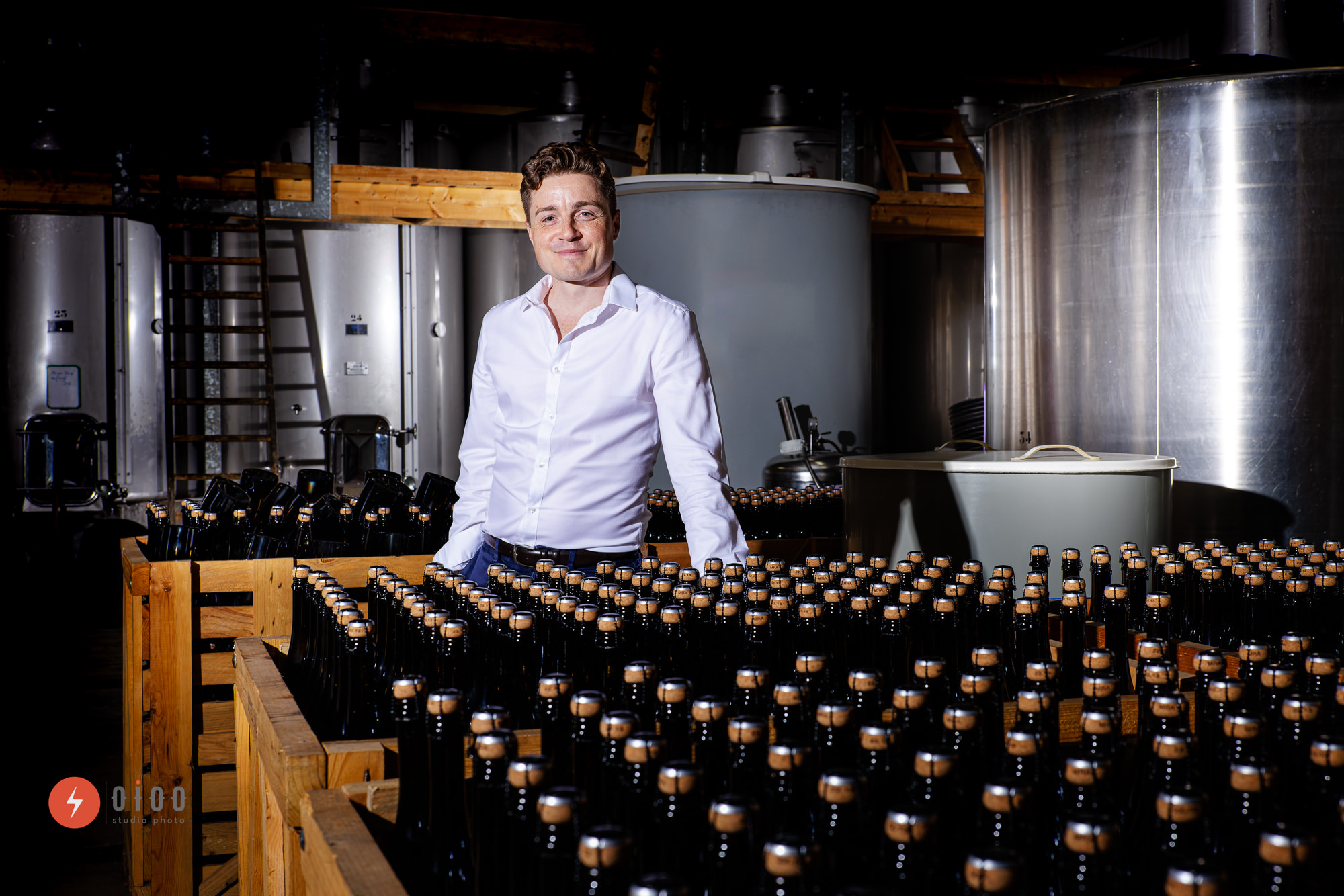 photo de la banque d'images exclusive du domaine viticole Musset-Roullier : portrait de l'un des gérants parmi les caisses de bouteilles
